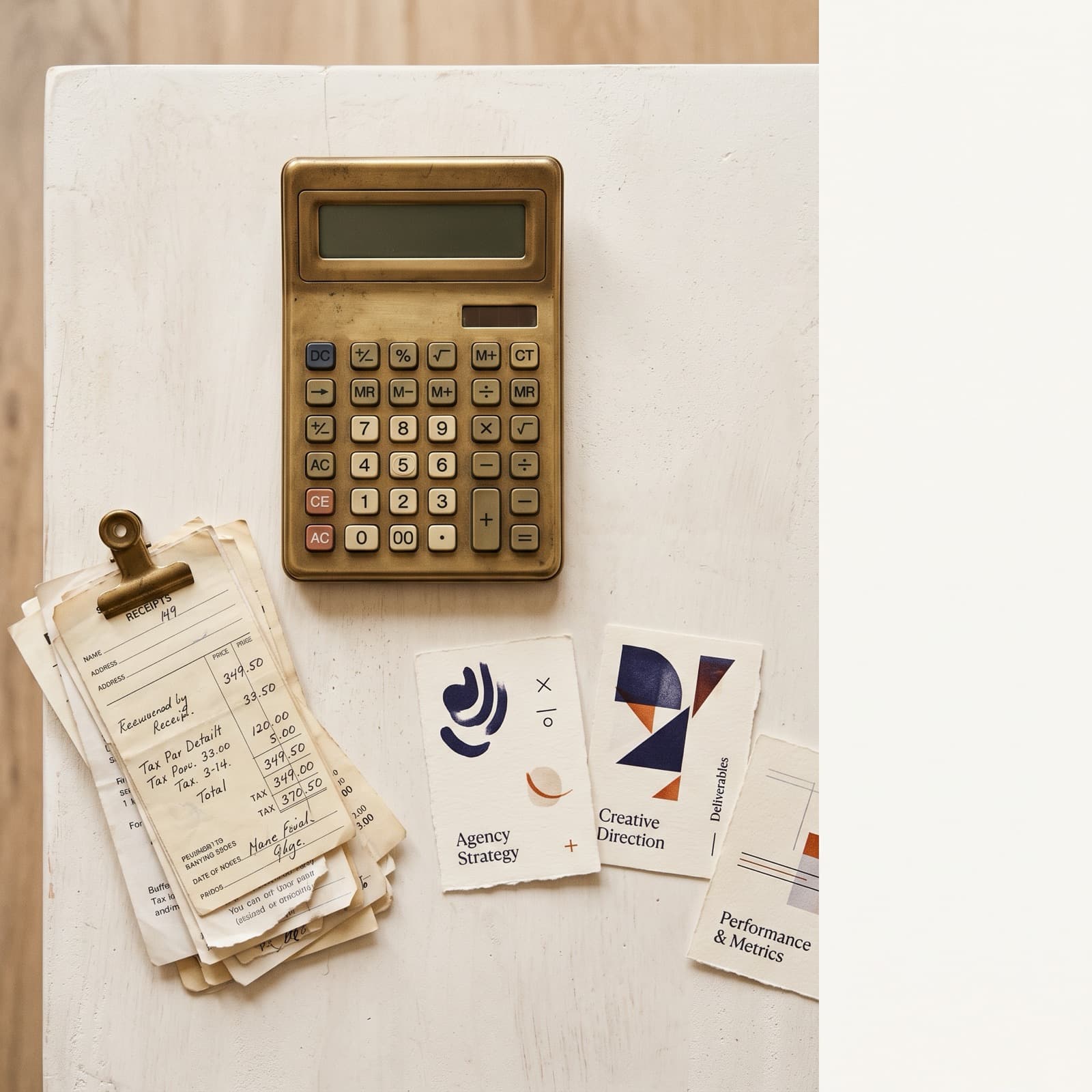 Redaktionel oversigts-flat lay af en messing-regnemaskine, stablede papirkvitteringer og fire små on-brand produktkort på en varm off-white nordisk studieflade med brændt orange og dyb blæk accenter.