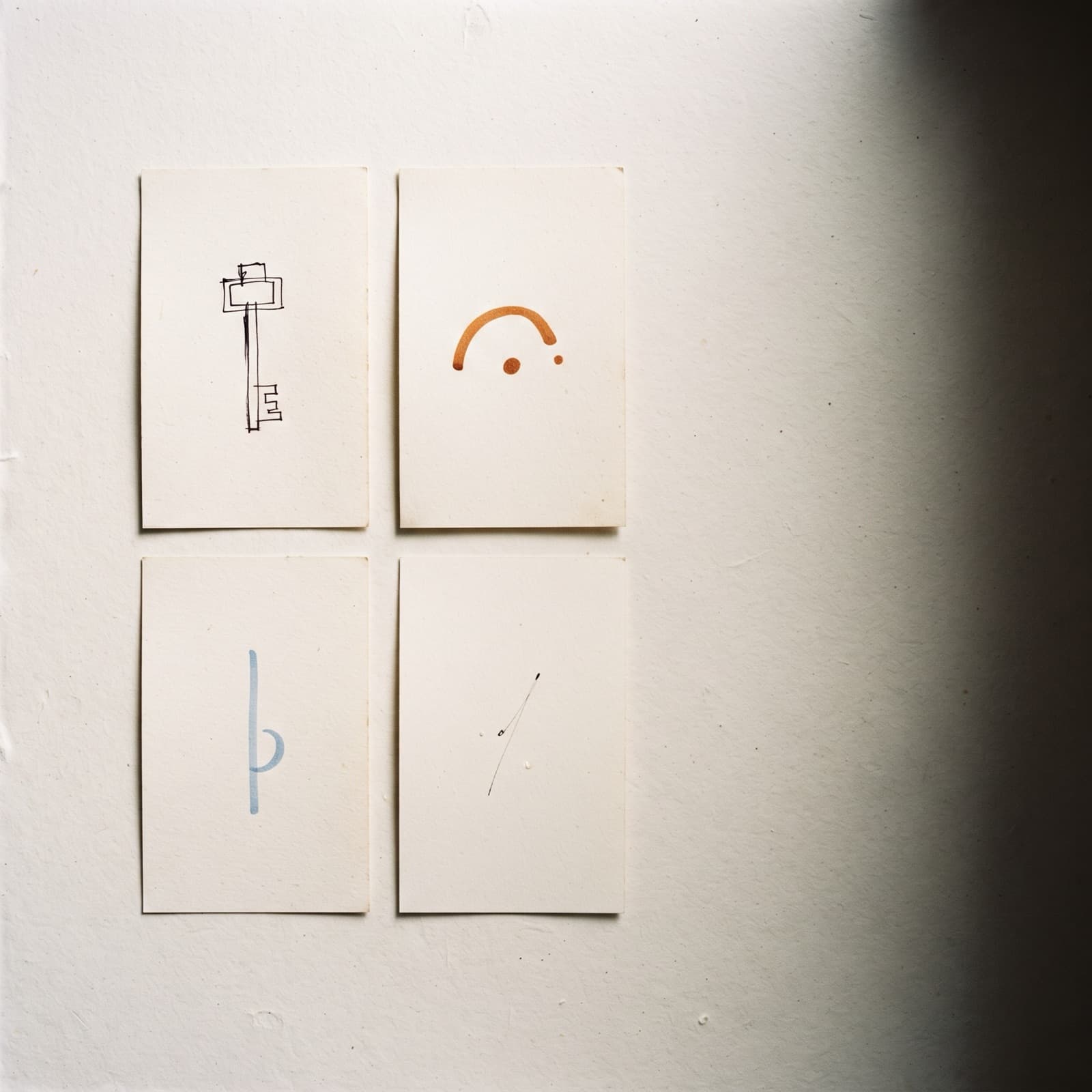 Editorial overhead flat lay of four small index cards labelled with a numbered script sequence on a warm off-white Nordic studio surface with burnt orange and deep ink accents.